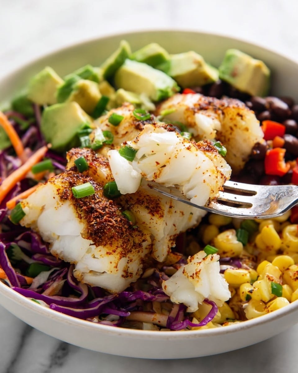 A white bowl on a white marbled texture holds a colorful dish with several layers: the bottom layer is a mix of yellow corn, black beans, diced red peppers, and green onions, followed by shredded purple and white cabbage mixed with small carrot strips on one side. On top, there are chunks of grilled white fish with a browned, slightly crispy crust sprinkled with spices. In the back, there are large pieces of green avocado cubes. A silver fork is seen holding a flake of the white grilled fish in the foreground, with some green onion pieces sprinkled on the fish. Photo taken with an iphone --ar 4:5 --v 7