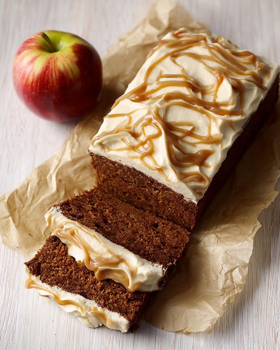The image shows a rectangular loaf of dark brown cake with thick, creamy white frosting on top, swirled with light brown caramel ribbons in a decorative pattern. Two slices from the loaf are placed in front, showing the cake’s dense texture and a layer of the same white frosting inside. The cake and slices rest on crumpled parchment paper over a white marbled surface. To the left of the cake, there is a whole red and yellow apple. Photo taken with an iphone --ar 4:5 --v 7
