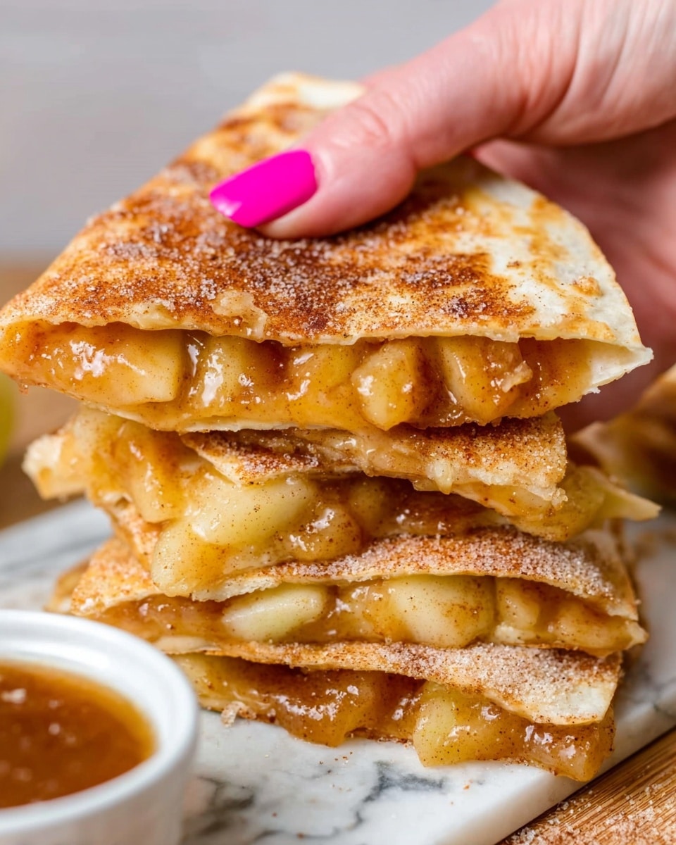 A stack of three folded quesadillas is shown on a light wooden board. Each quesadilla has two golden-brown, slightly crispy tortilla layers with a bubbly texture, filled with soft, chunky pieces of cooked yellow apple filling that looks juicy and caramelized. Some apple pieces spill out between the layers and around the stack. In the background, there is a small white bowl filled with smooth, light brown caramel sauce placed on a white marbled surface. The photo focuses closely on the quesadillas, showing their warm colors and textures in detail. Photo taken with an iphone --ar 4:5 --v 7