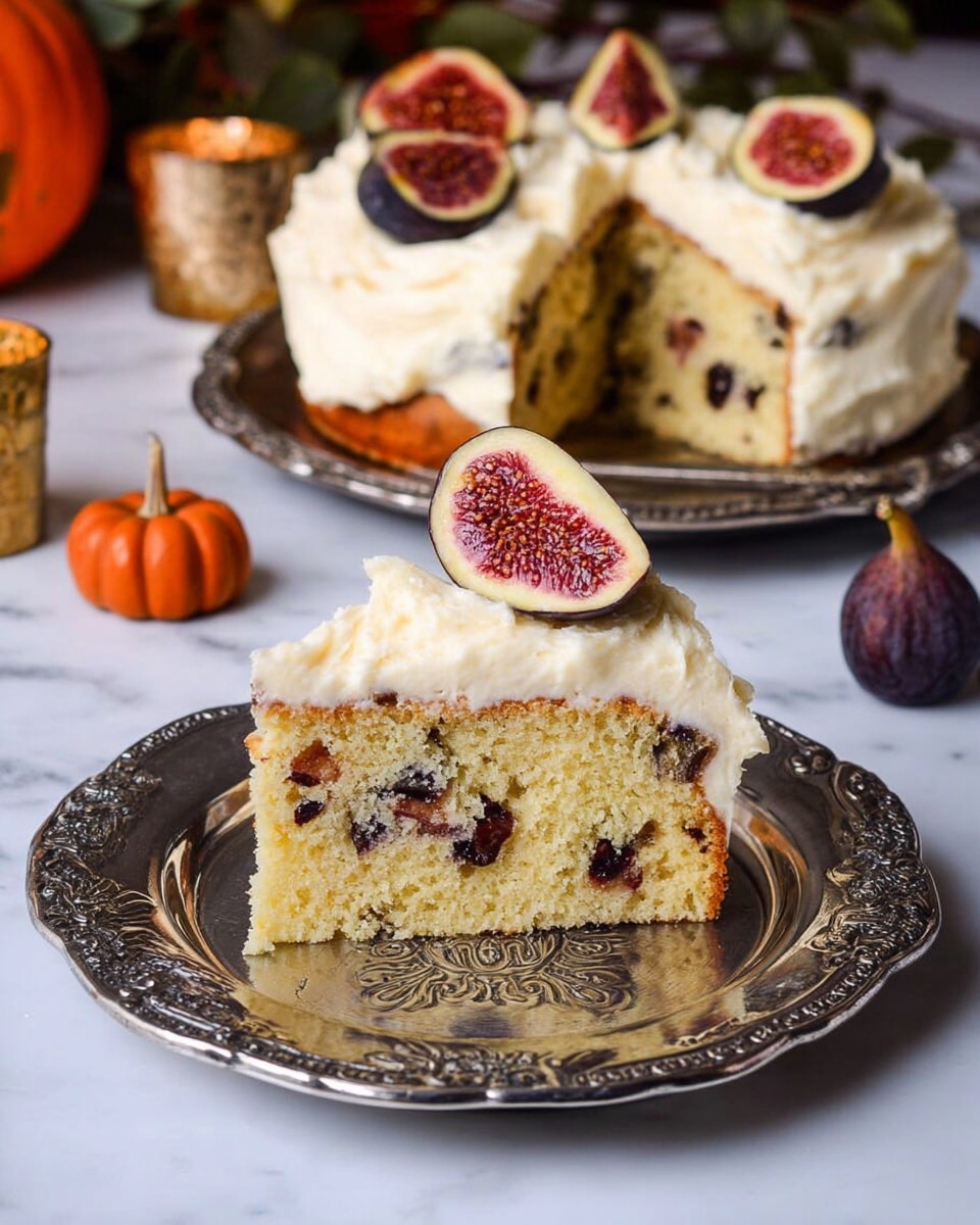 A single-layer round cake with a golden brown base sits on a silver patterned tray, topped thickly with creamy, pale yellow frosting that looks fluffy and rich. On top of the frosting, several fresh figs, some whole and some cut in half, display their deep purple skin and bright red, seed-speckled inside, arranged neatly in the center. The background shows white pumpkins and a detailed patterned tapestry. The setting rests on a white marbled texture. Photo taken with an iphone --ar 4:5 --v 7