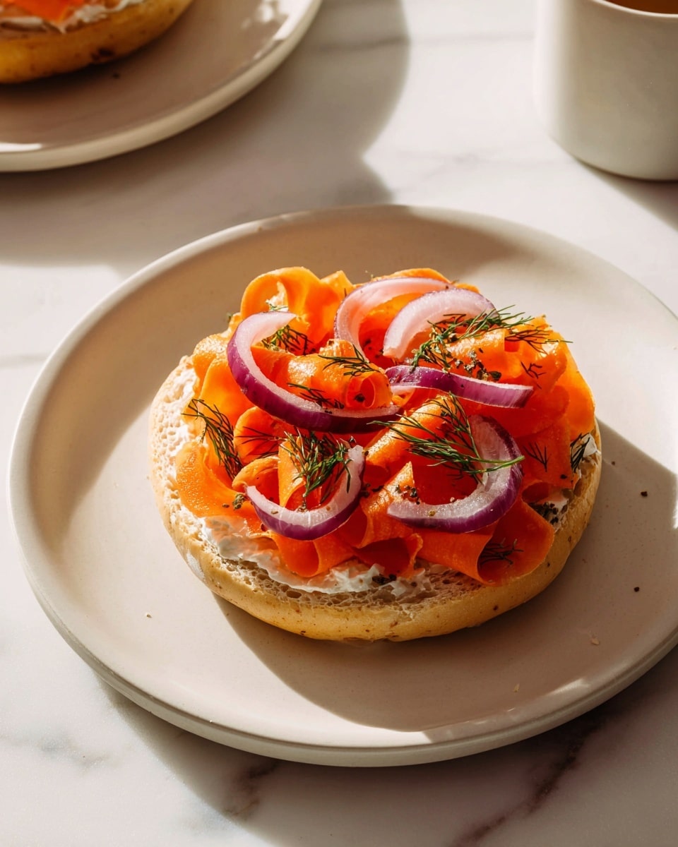 The image shows a toasted bagel cut in half, each half topped with three layers: the first layer is a smooth white cream cheese spread, the second layer is bright orange carrot ribbons rolled and curled across the surface, and the third layer has thin purple rings of red onion and small green dill sprigs sprinkled on top, adding texture and color contrast. The bagel halves rest on a wooden board with a second toasted bagel half displayed on a white plate in the blurred background, all set against a white marbled surface. Photo taken with an iphone --ar 4:5 --v 7