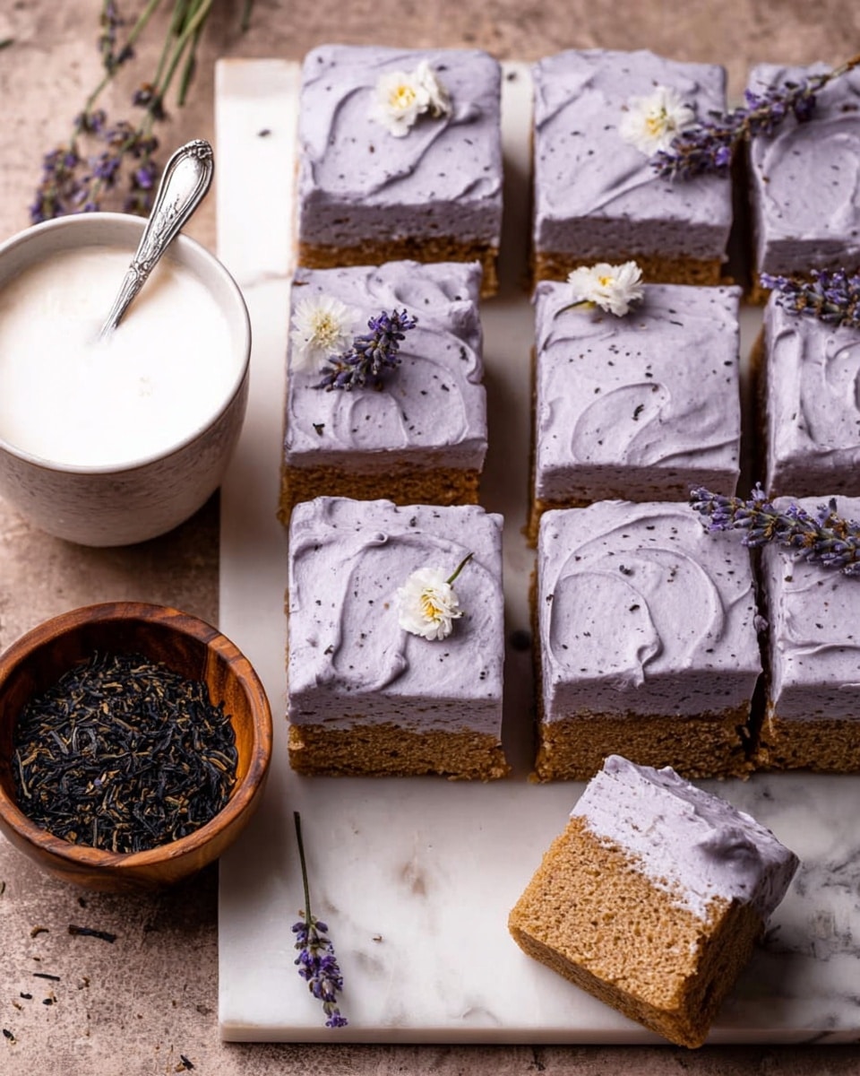 The image shows a close-up of a square slice of cake with two layers. The bottom layer is light brown, with a soft and crumbly texture. The top layer is a thick coating of pale lavender frosting, smooth with a slightly matte finish. The cake is decorated with a small dry lavender flower and a white flower on top. Next to the cake, there is a small wooden bowl filled with dried lavender buds. The background is a white marbled texture. Photo taken with an iphone --ar 4:5 --v 7