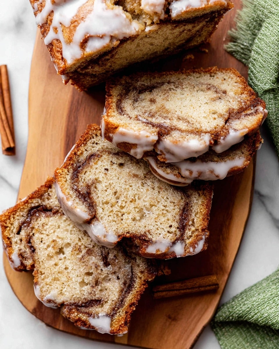 The image shows several slices of cinnamon swirl banana bread on a wooden board placed on a white marbled surface. The bread has a light golden brown color with darker brown cinnamon swirls inside, giving it a marbled look. Each slice has a shiny white glaze drizzle on top, mostly along the edges. The texture of the bread looks soft and moist with small holes throughout. A green cloth napkin is visible in the top right corner, and there is a small piece of cinnamon stick near the bottom left edge of the board. Photo taken with an iphone --ar 4:5 --v 7
